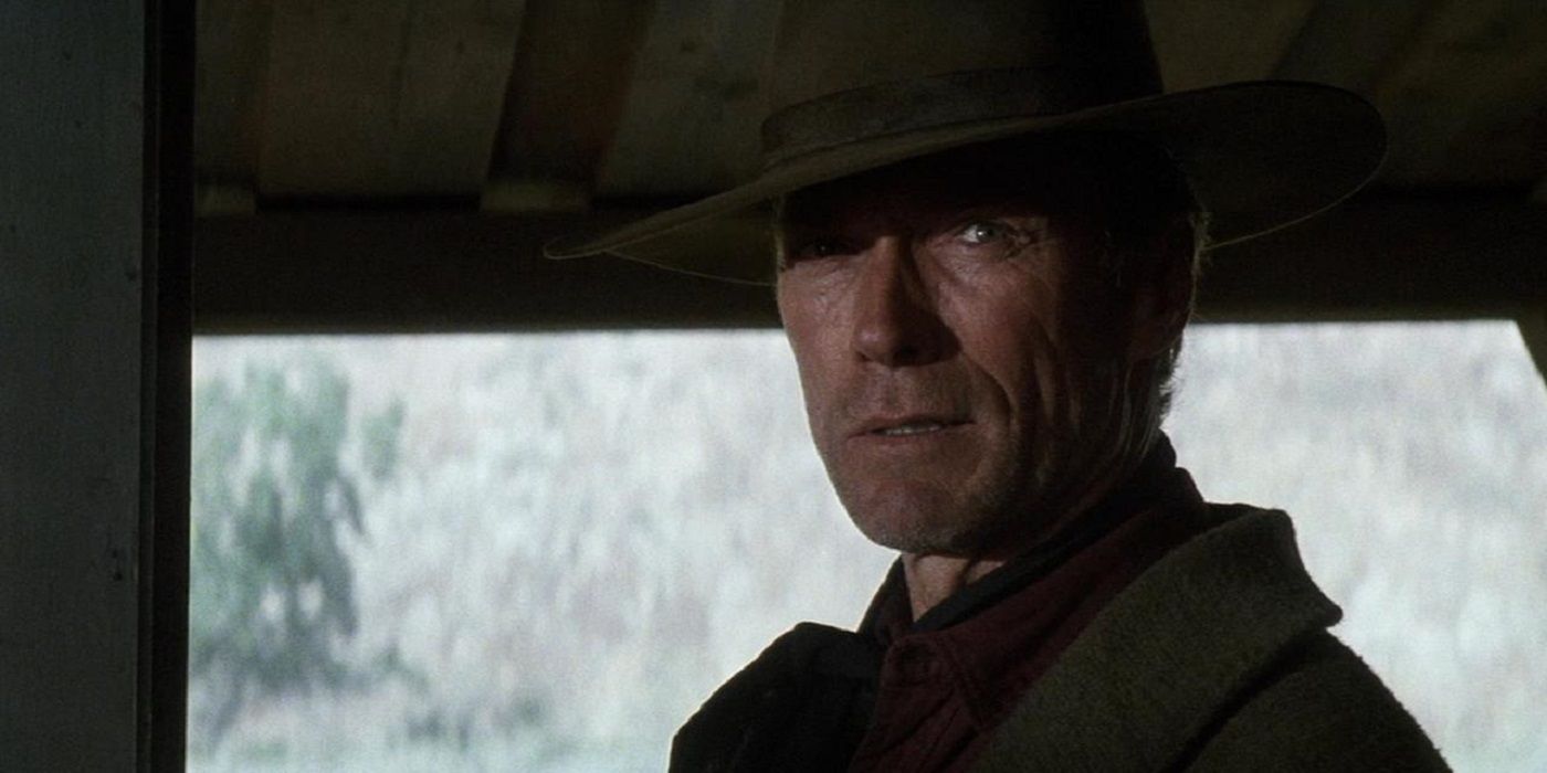 Clint Eastwood as William Munny sneering at the camera in Unforgiven.
