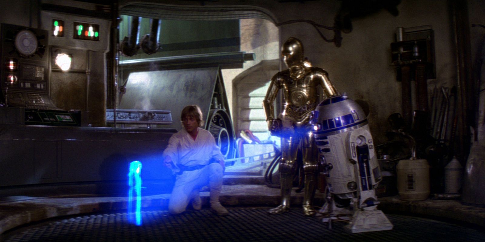 Luke Skywalker and C-3PO watch R2-D2 display a hologram of Princess Leia in Star Wars A New Hope