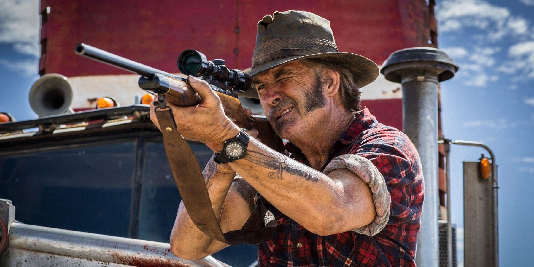 Mick Taylor aiming a rifle in Wolf Creek