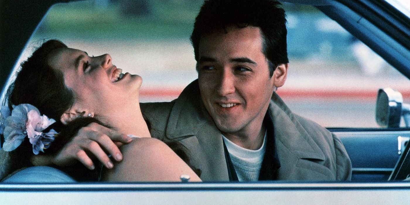 Ione Skye laughs while in a car with John Cusack in ...Say Anything.
