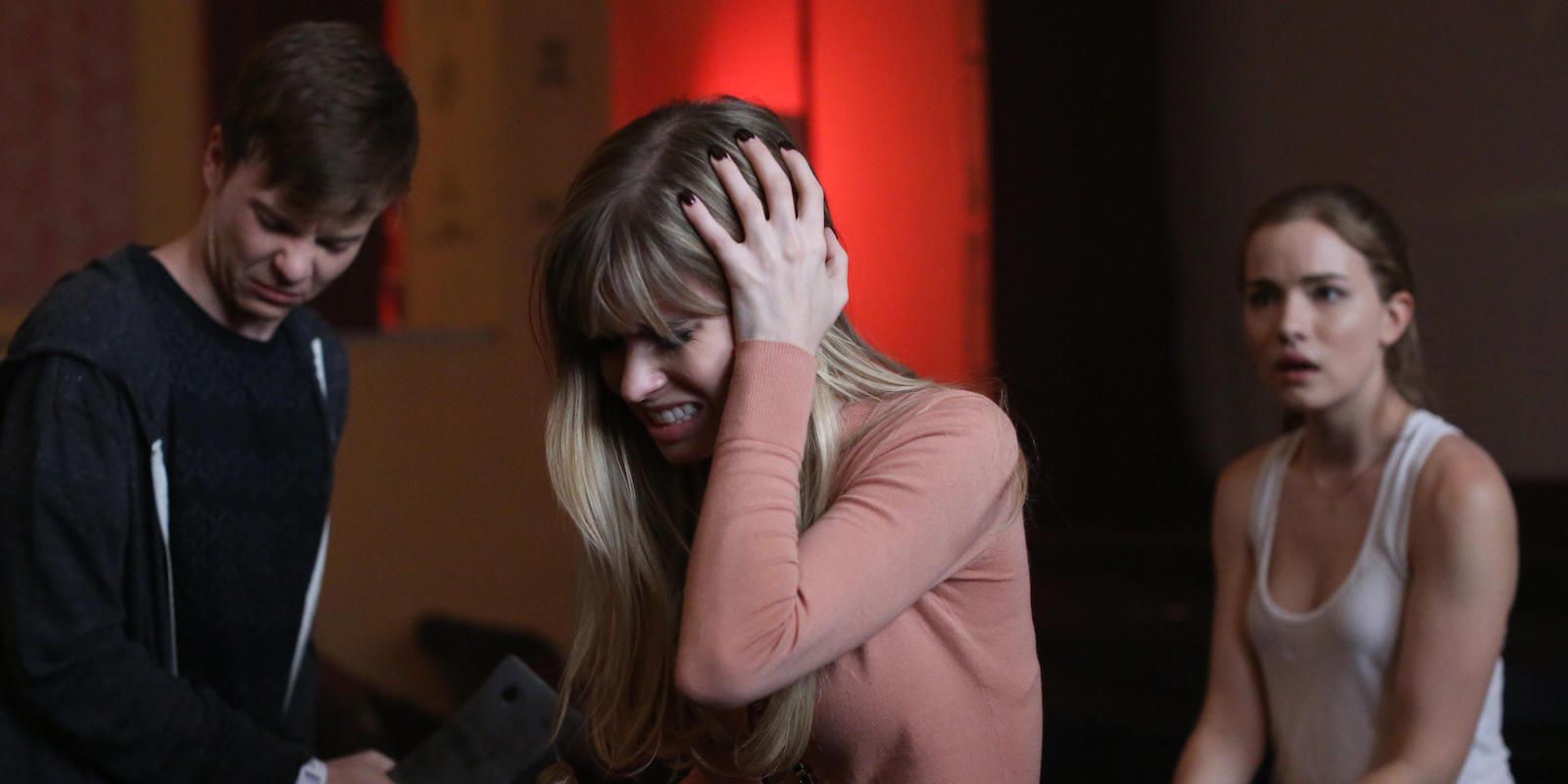 Brooke clutches her head with Emma and Noah in the TV show Scream.