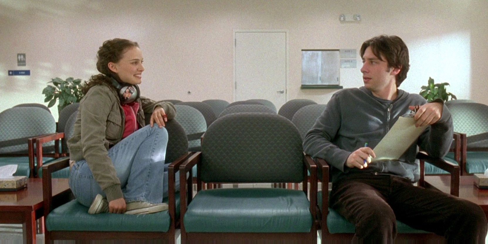 Natalie Portman and Zach Braff sitting on chairs and looking at each other in Garden State