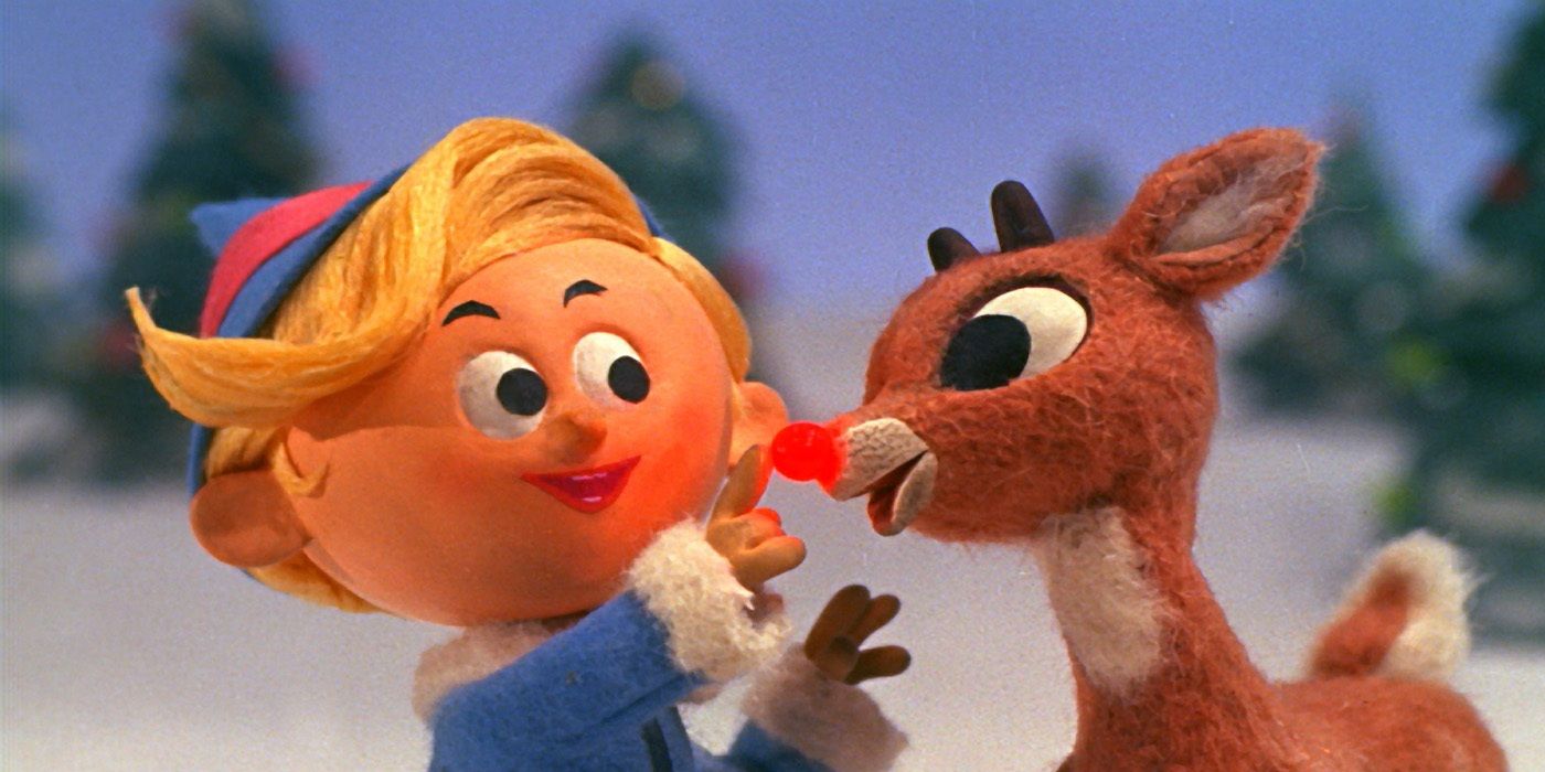 An elf patting Rudolph in red nosed reindeer