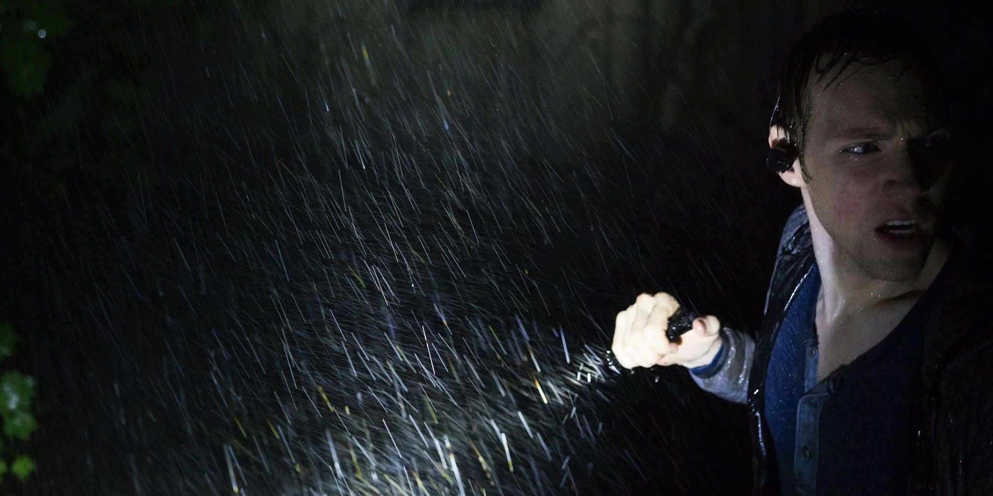James Allen McCune as James Donahue hoilding a flashlight in the rain in Blair Witch (2016)