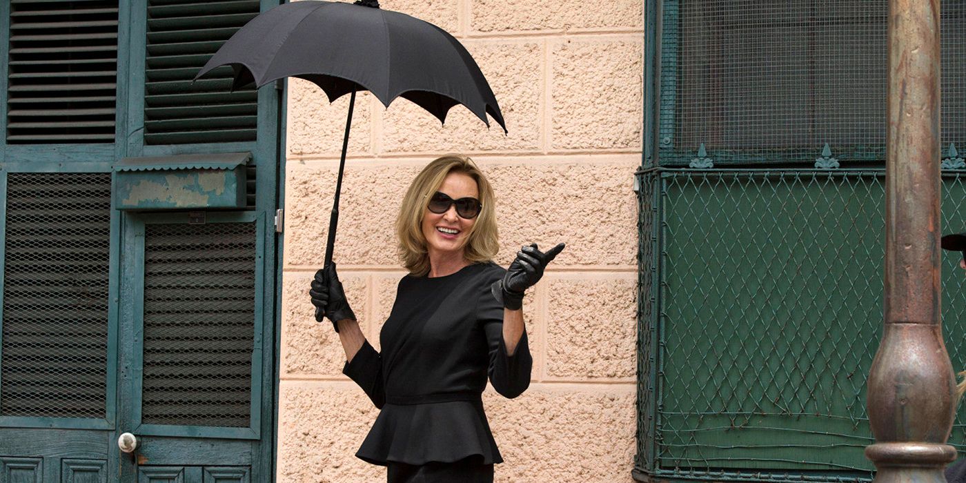 Fiona Goode holding an umbrella and walking on the street in American Horror Story Coven