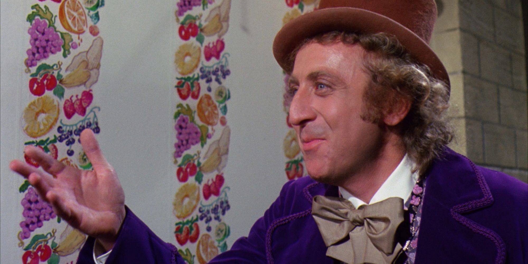 Gene Wilder as Willy Wonka in front of the flavored wallpaper in Willy Wonka and the Chocolate Factory