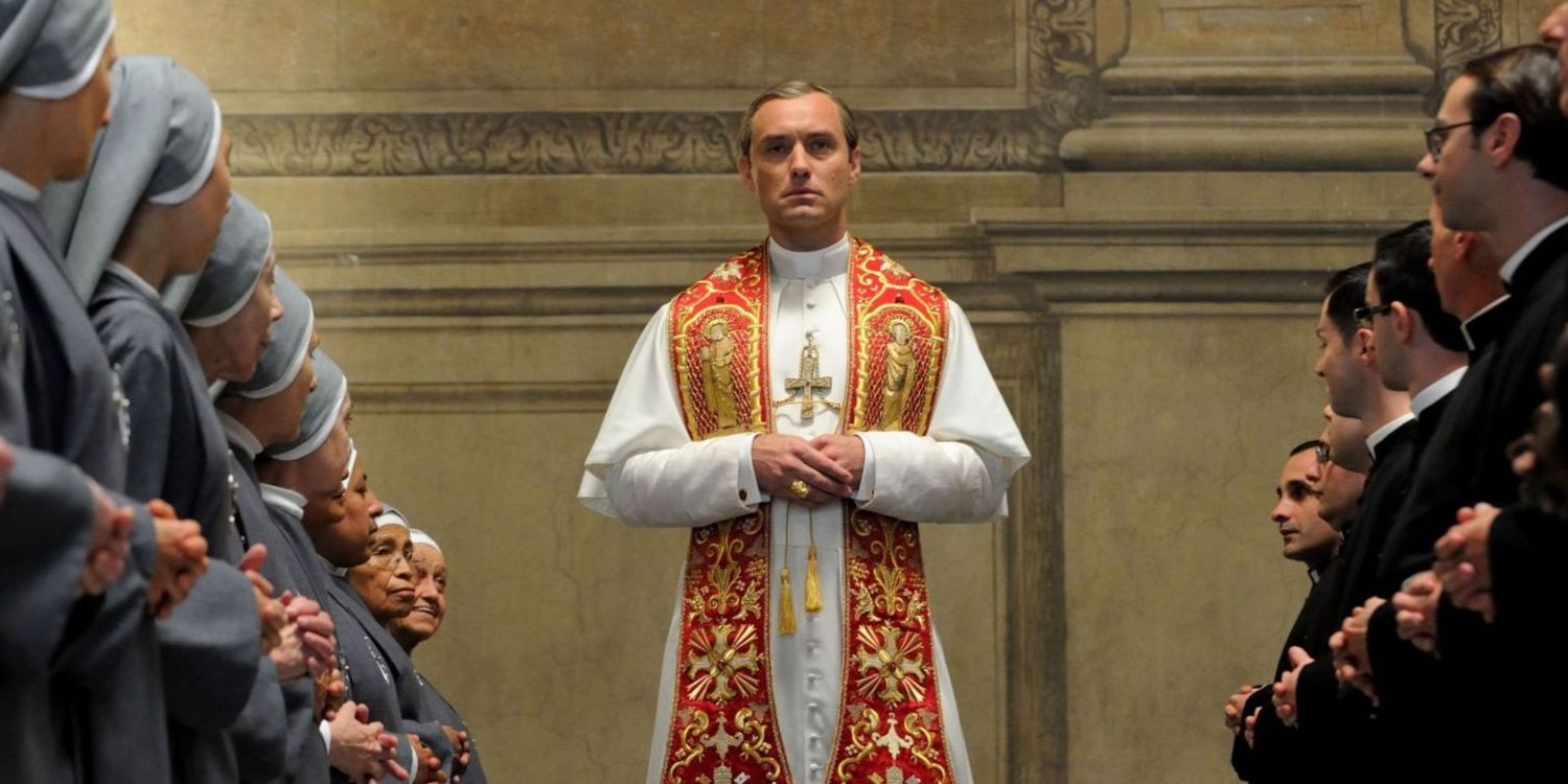 Jude Law stands between a group of priests and nuns in the Young Pope