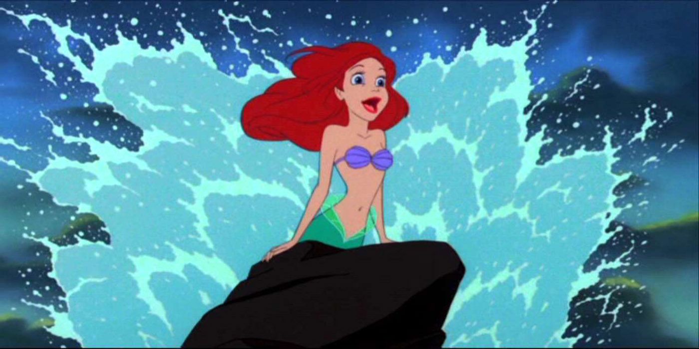 Ariel on a rock as the waves splash behind her in The Little Mermaid