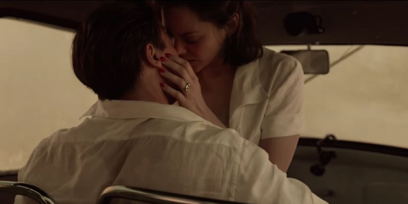 Brad Pitt and Marion Cotillard kiss in a car in the movie Allied.