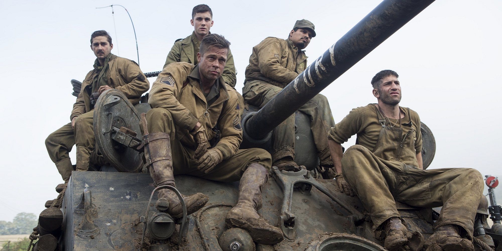 The tank crew (Brad Pitt, Shia LaBeouf, Jon Bernthal, Michael Pena, Logan Lerman) sit on a tank in Fury