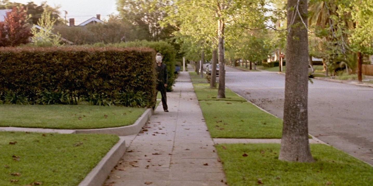 Michael Myers lurks behind a bush in Halloween 