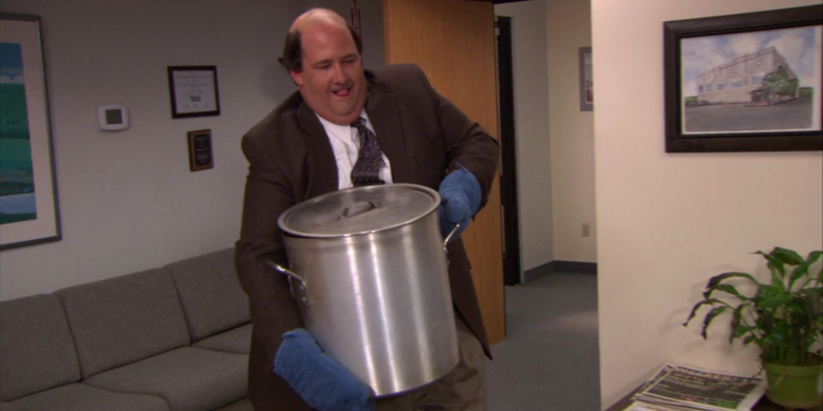 Kevin carries chili into the office in The Office