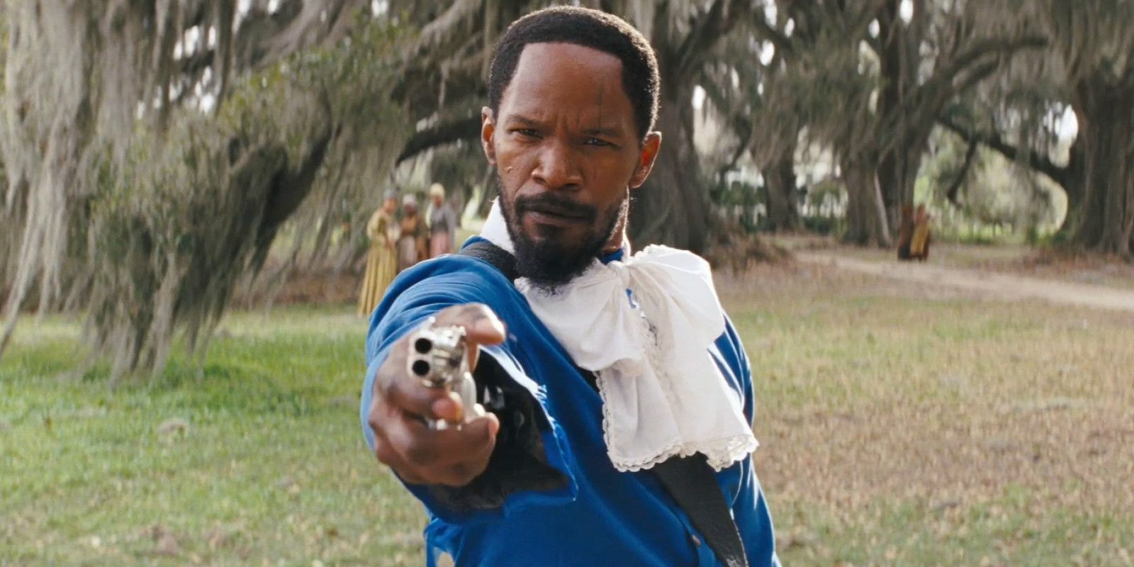 Jamie Foxx pointing a gun in a blue suit in Django Unchained