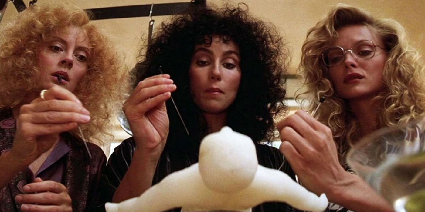 Jane, Alex, and Sukie stab a wax doll with needles in The Witches of Eastwick
