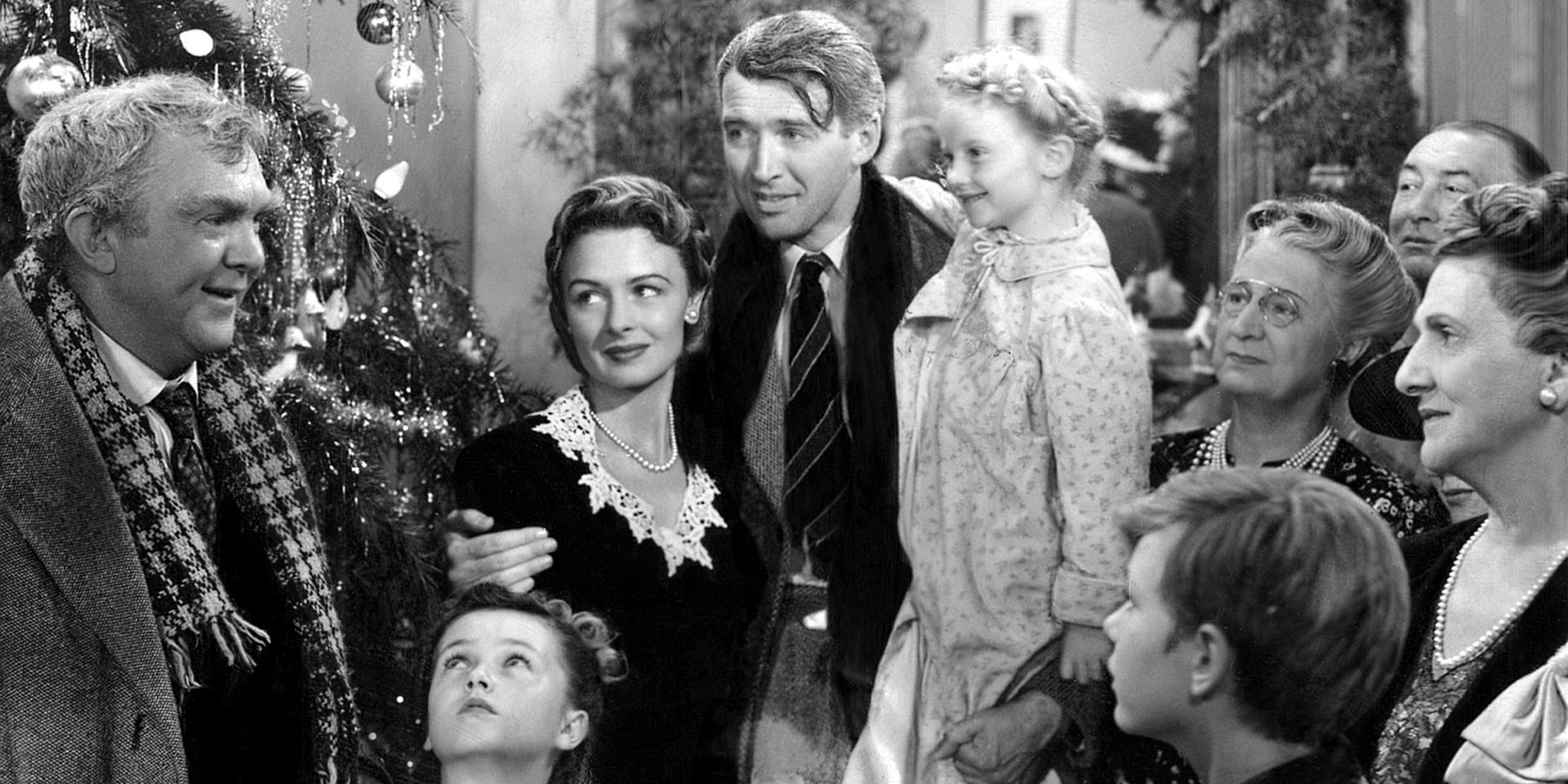 A group of people gathered around inside a house with Christmas decorations in It's A Wonderful Life