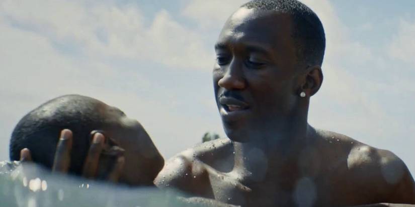 Mahershala Ali holding a child in the water in Moonlight