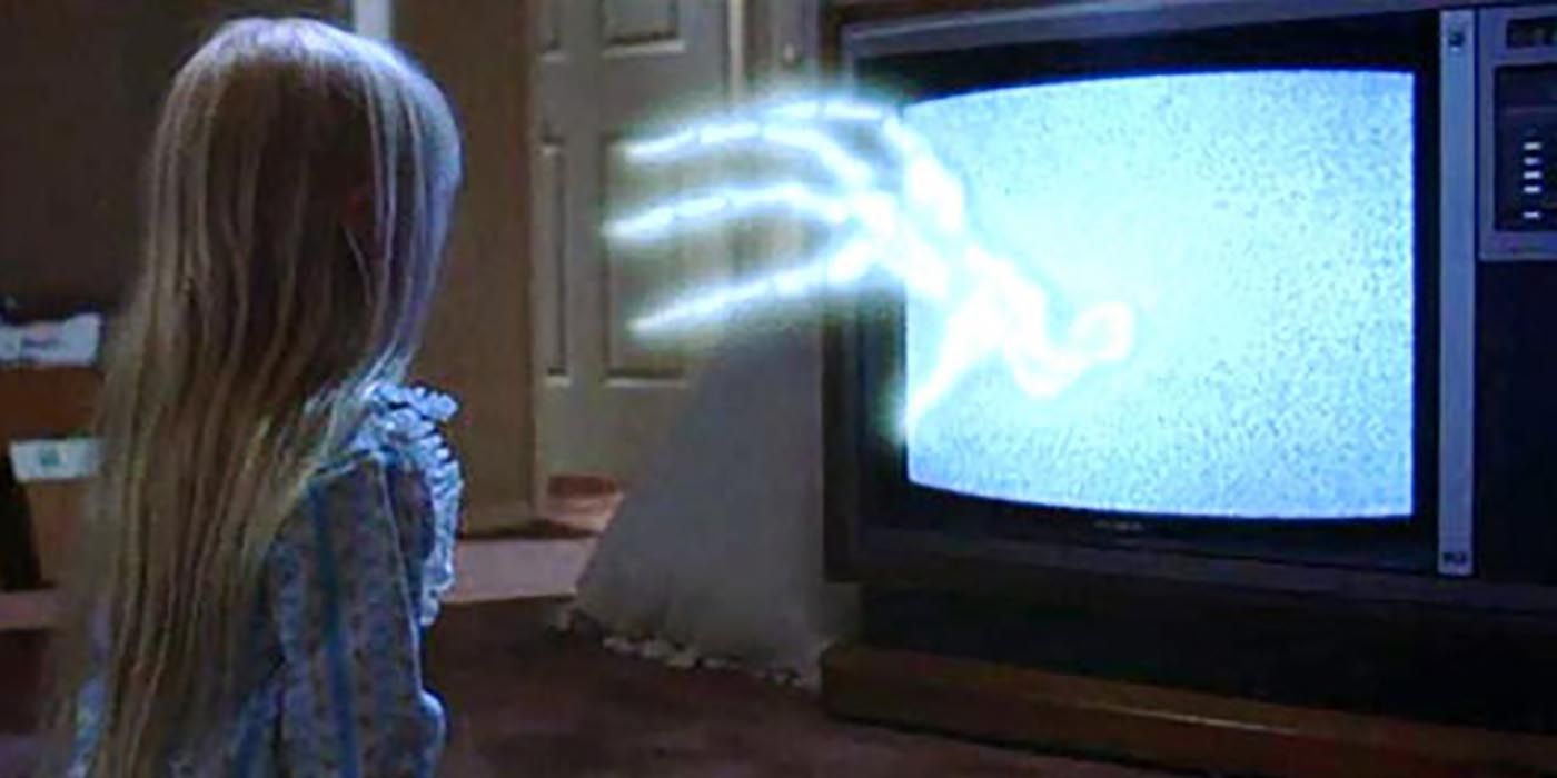 A ghostly hand reaches out the static on the TV at Carol Anne in Poltergeist