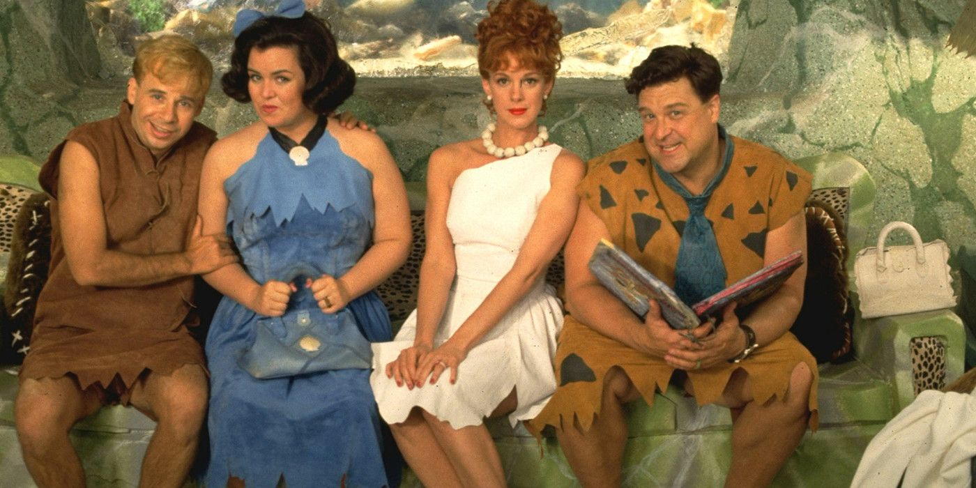 Fred, Wilma, Barney, and Betty sit on a rock in The Flintstones