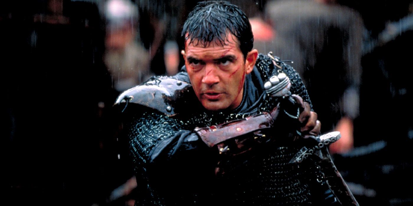 Antonio Banderas in the rain holding a sword