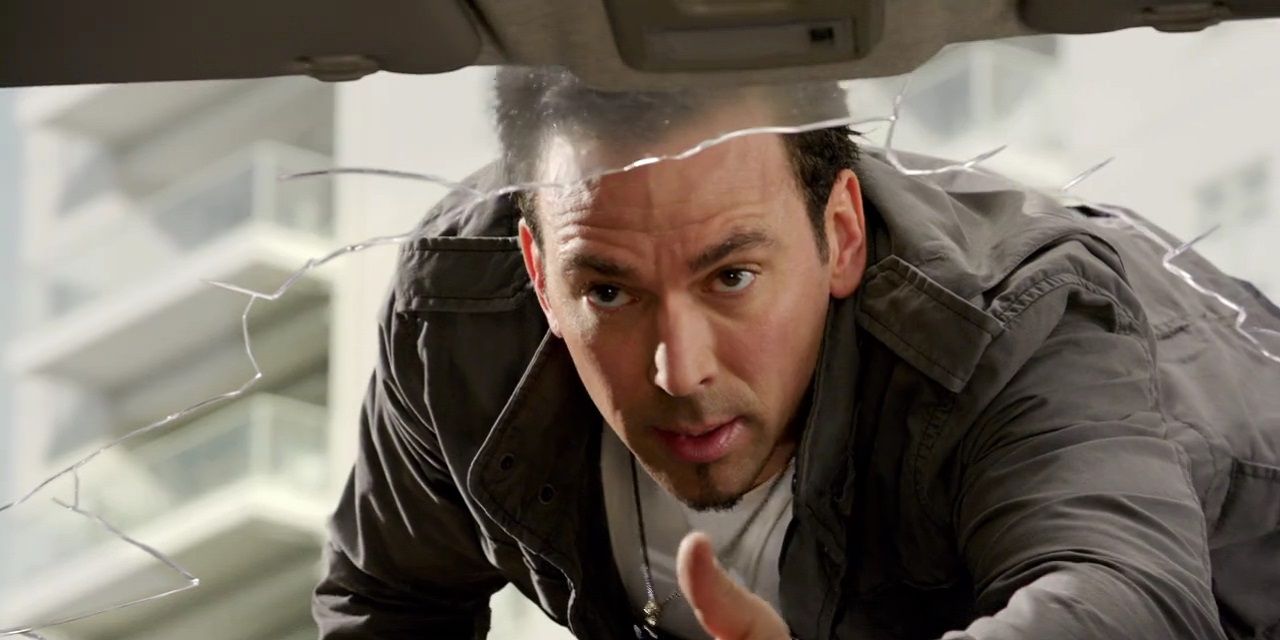 Tommy Oliver reaching through a car window to help someone in Power Rangers Megaforce
