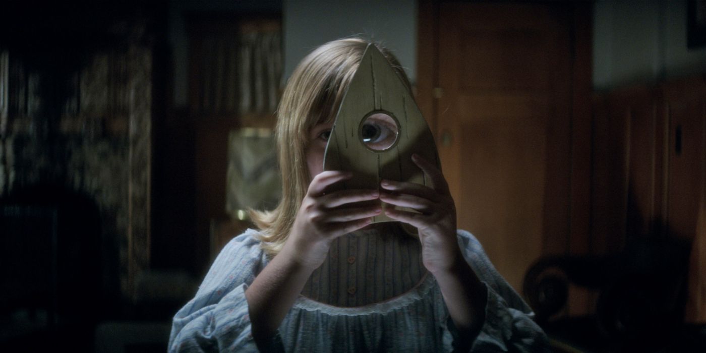 Lulu Wilson olhando através de um vidro em Ouija Origem do Mal 