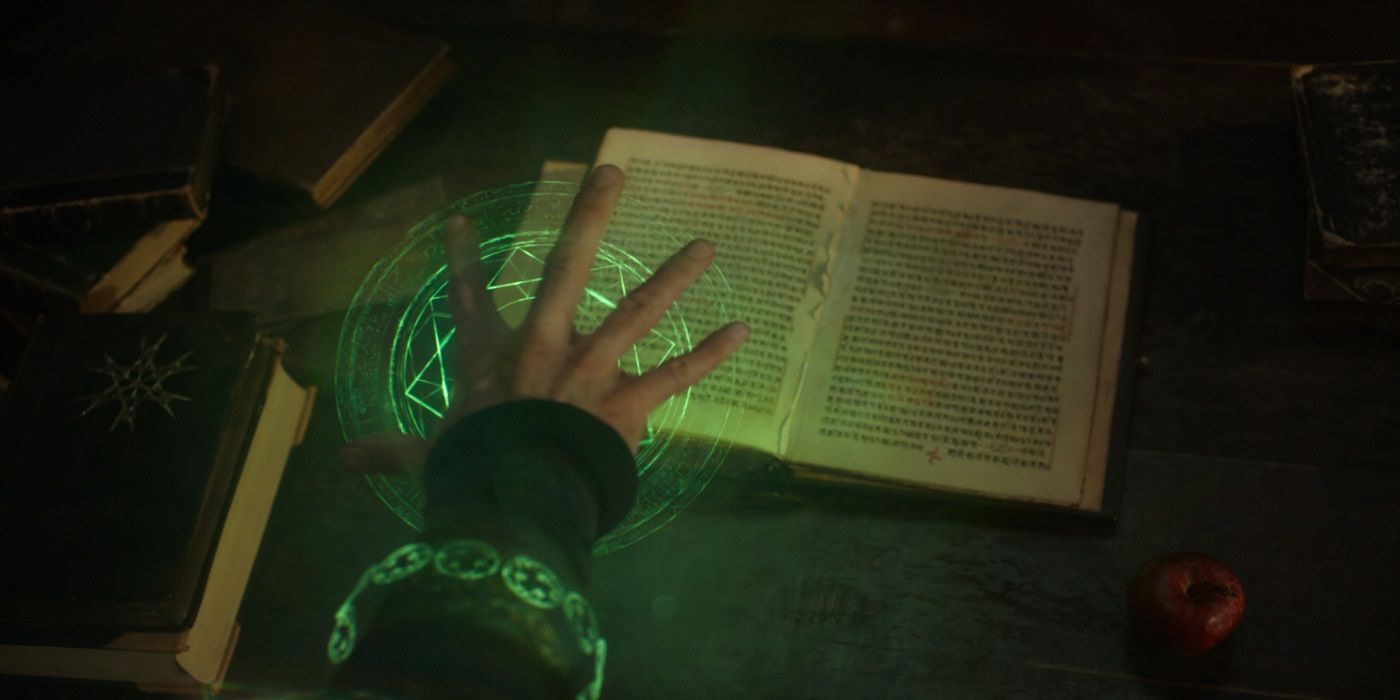 A hand hovers over a magical book from Doctor Strange 