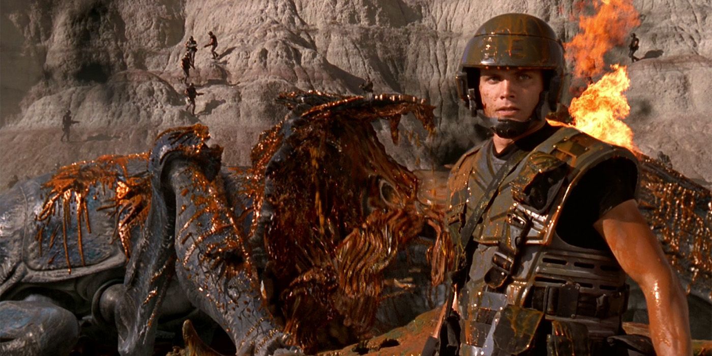 Rico standing in front of a dead bug in Starship Troopers
