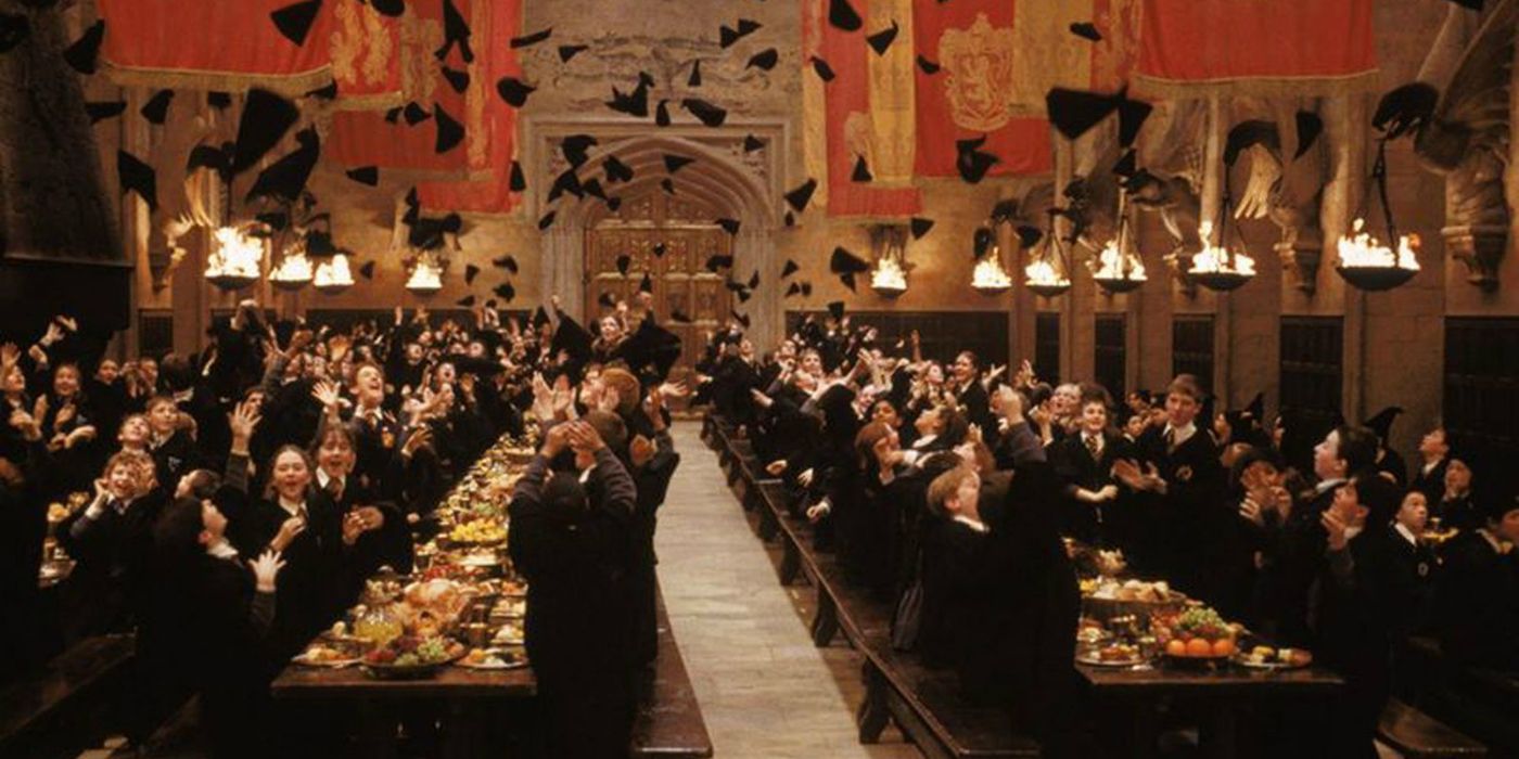 Alunos de Hogwarts jogando seus chapéus no Salão Principal