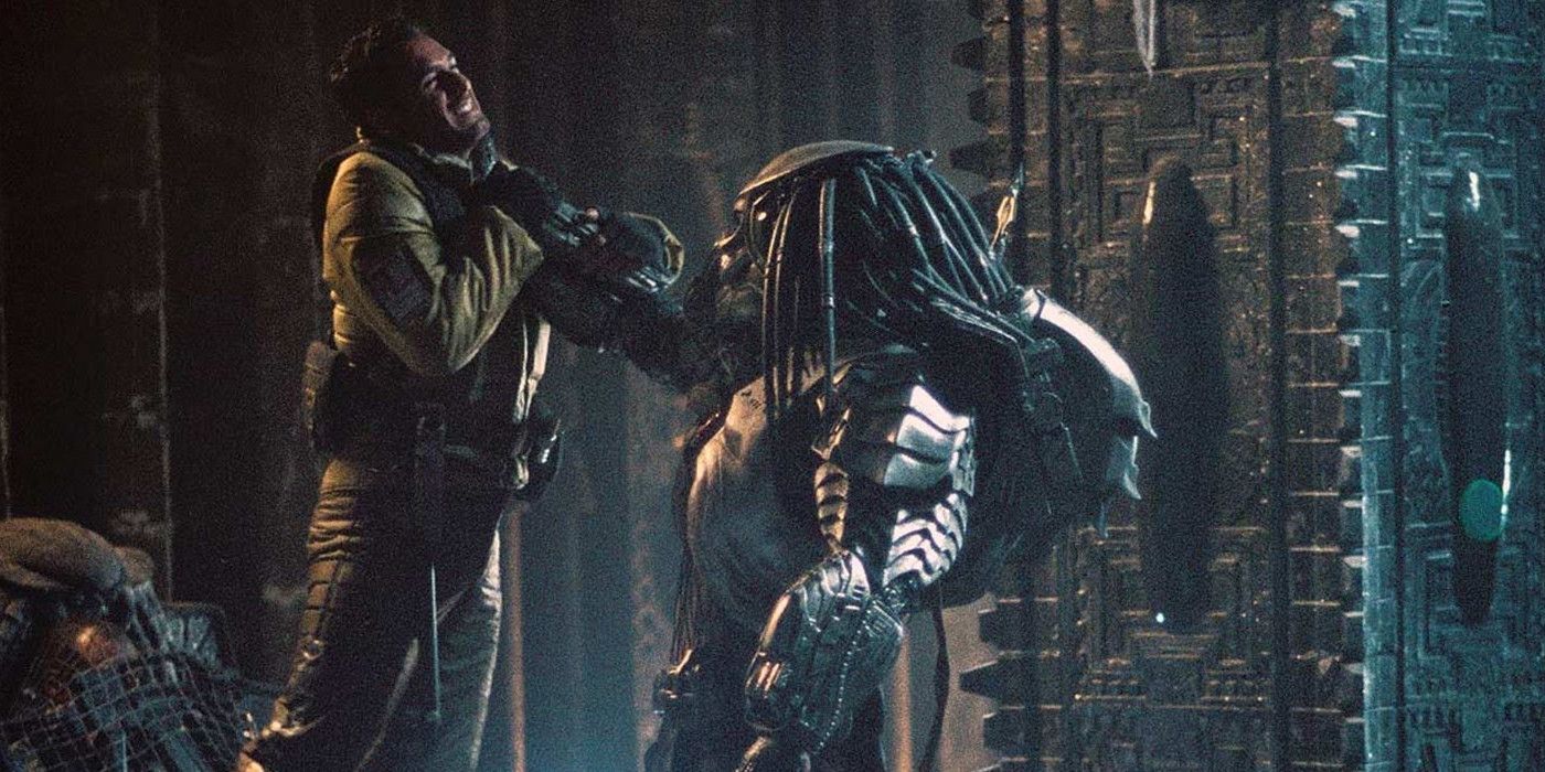 Predator holding someone up by their neck in Alien vs Predator.