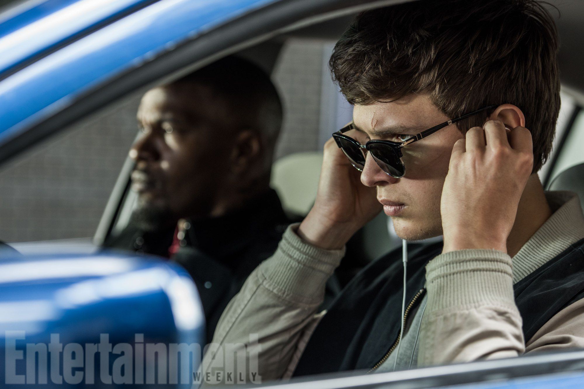 Baby (ANSEL ELGORT) and Bats (JAMIE FOXX) on the way to the post office job with Buddy (JON HAMM) and Darling (EIZA GONZALEZ) as cops pull up next to them in TriStar Pictures' BABY DRIVER.