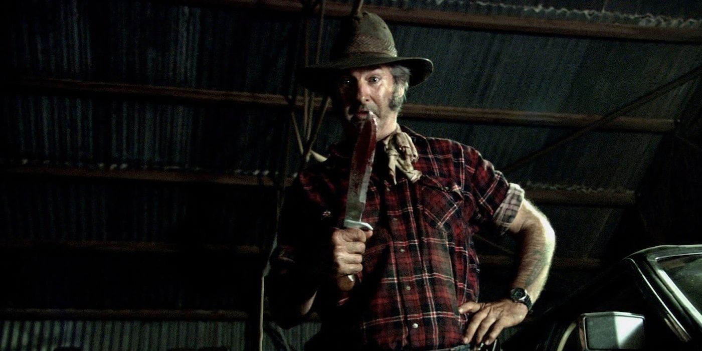 Mick segurando uma faca de caça em Wolf Creek