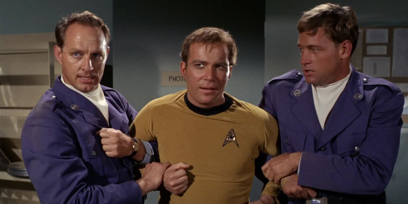 Kirk is held by two military men from Star Trek