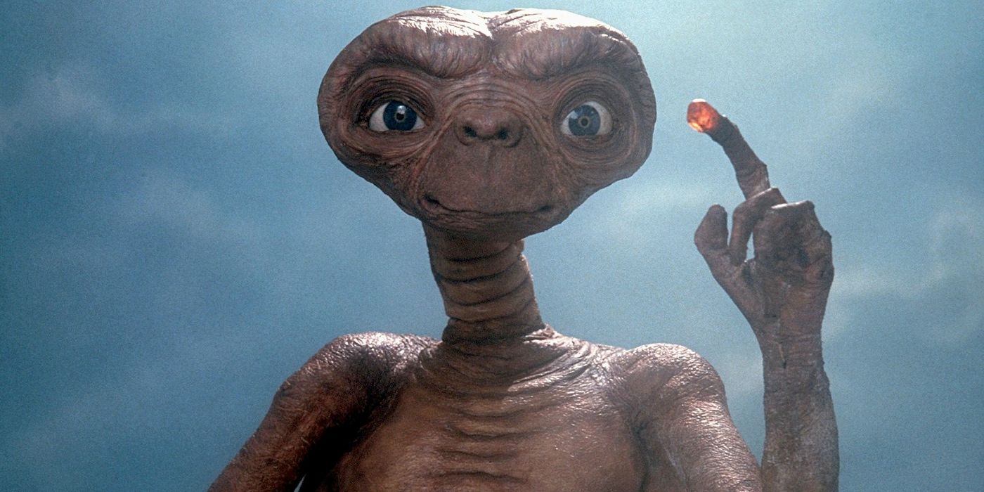 E.T. lights up his finger and points to the sky in E.T. The Extra-Terrestrial
