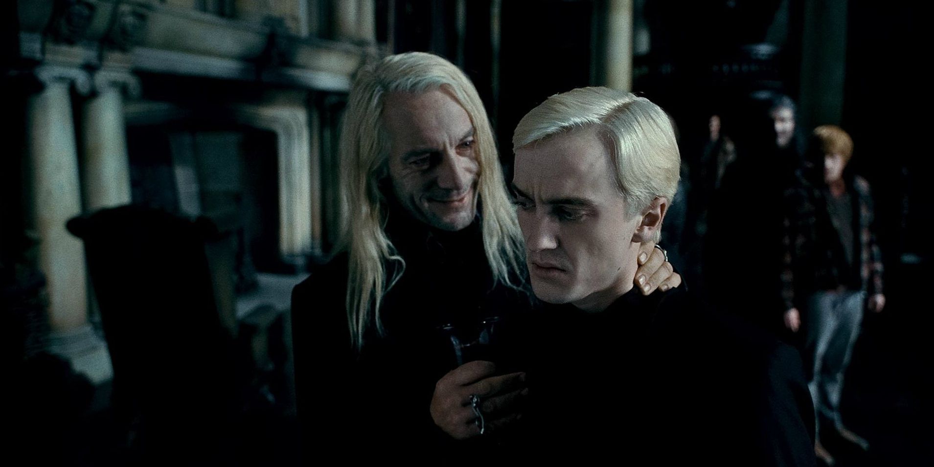 Lucius Malfoy hold Draco by the back of the neck in Deathly Hallows Part 1