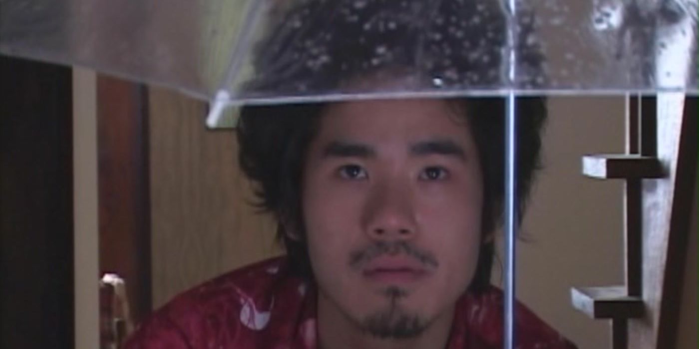 A man holding an umbrella in the movie Visitor Q