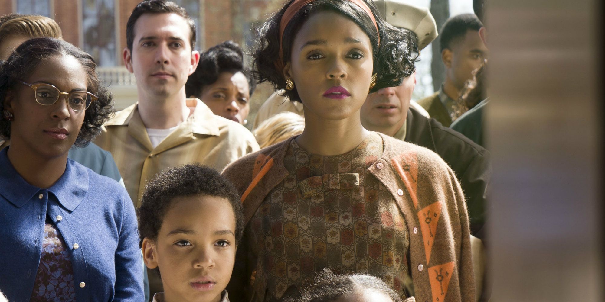 Mary (Janelle Monae) stands with a crowd to watch a report on a television in a store window in Hidden Figures