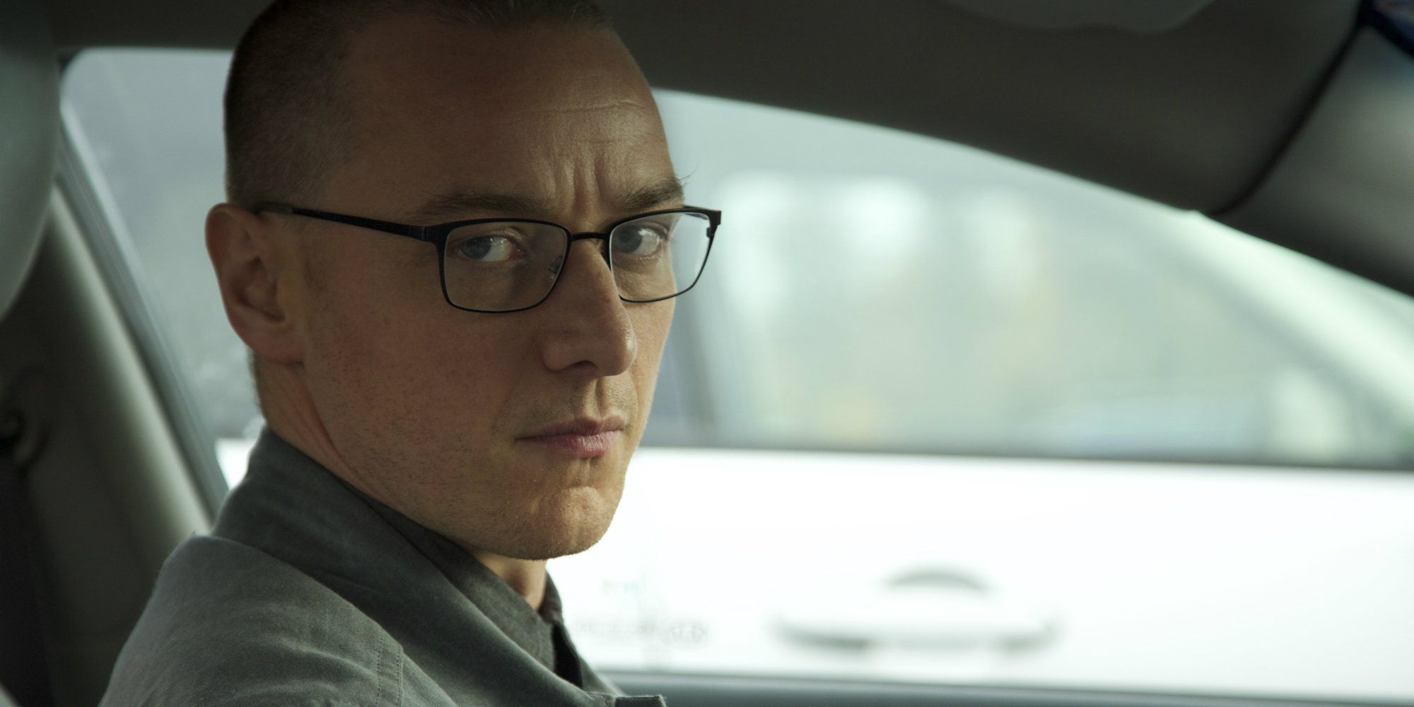 James McAvoy sitting in a car and wearing glasses in Split