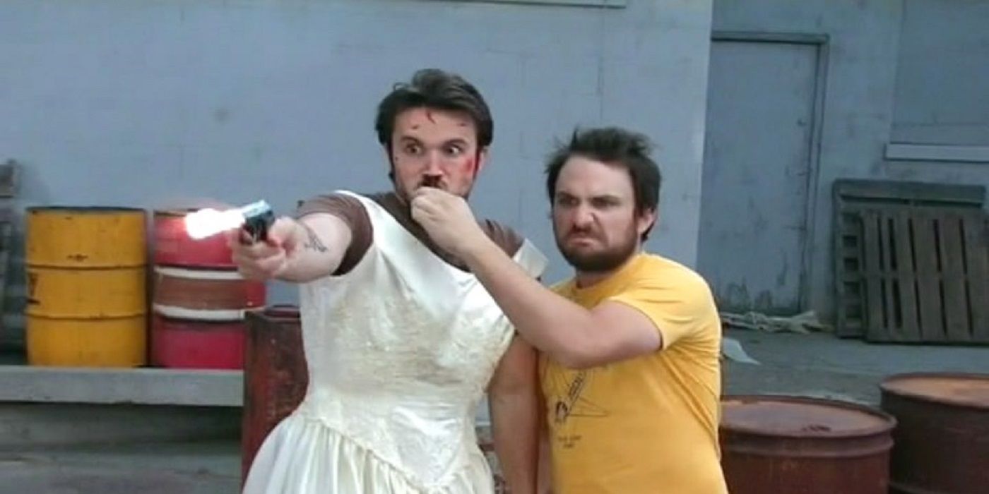 Mac points a gun while wearing a dress in It's Always Sunny In Philadelphia
