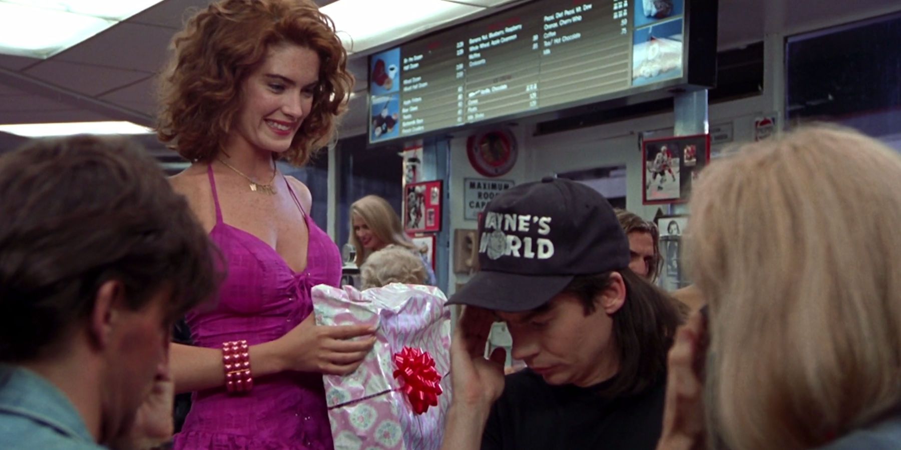 Lara Flynne Boyle como Stacy dando um presente a Wayne em Wayne's World