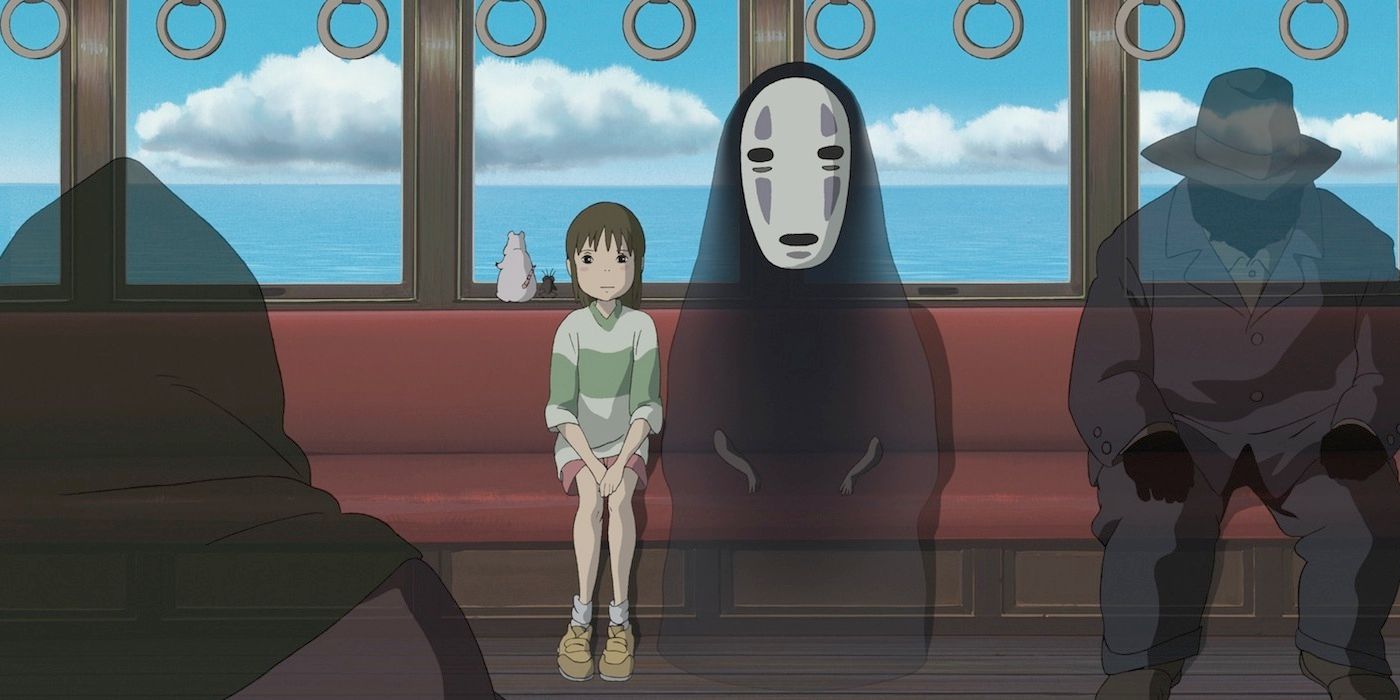 Chihiro sits next to a spirit on a train in Spirited Away