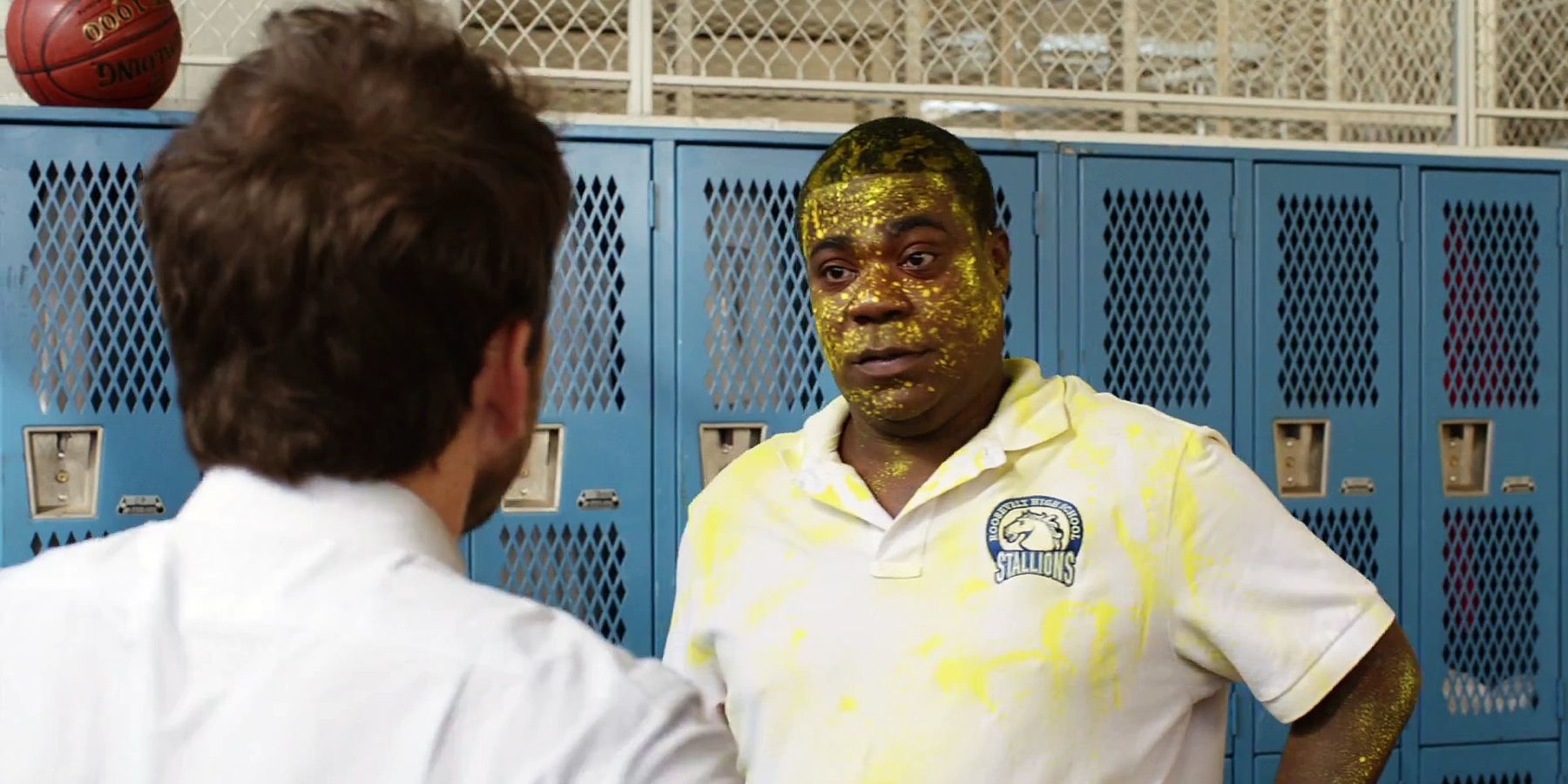 Charlie Day and Tracy Morgan covered in yellow paint talking in the locker room in Fist Fight
