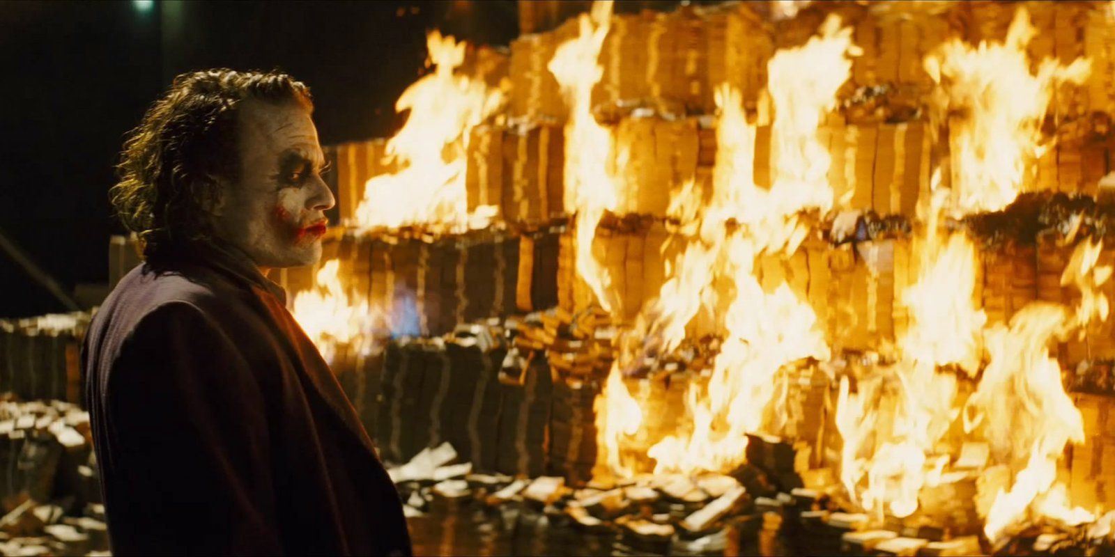 Heath Ledger as the Joker burning money in The Dark Knight