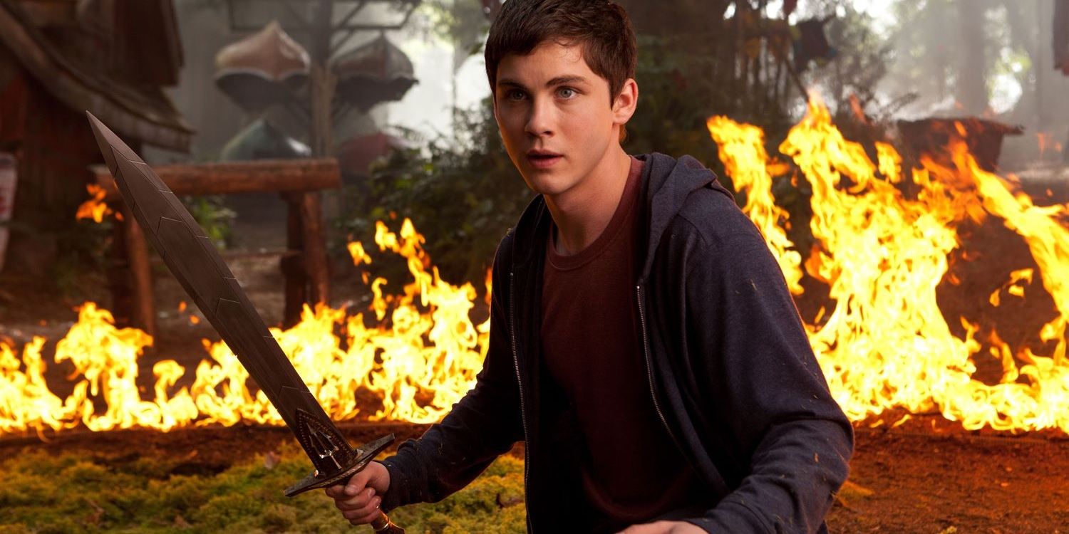 Logan Lerman as Percy Jackson in front of fire with a sword