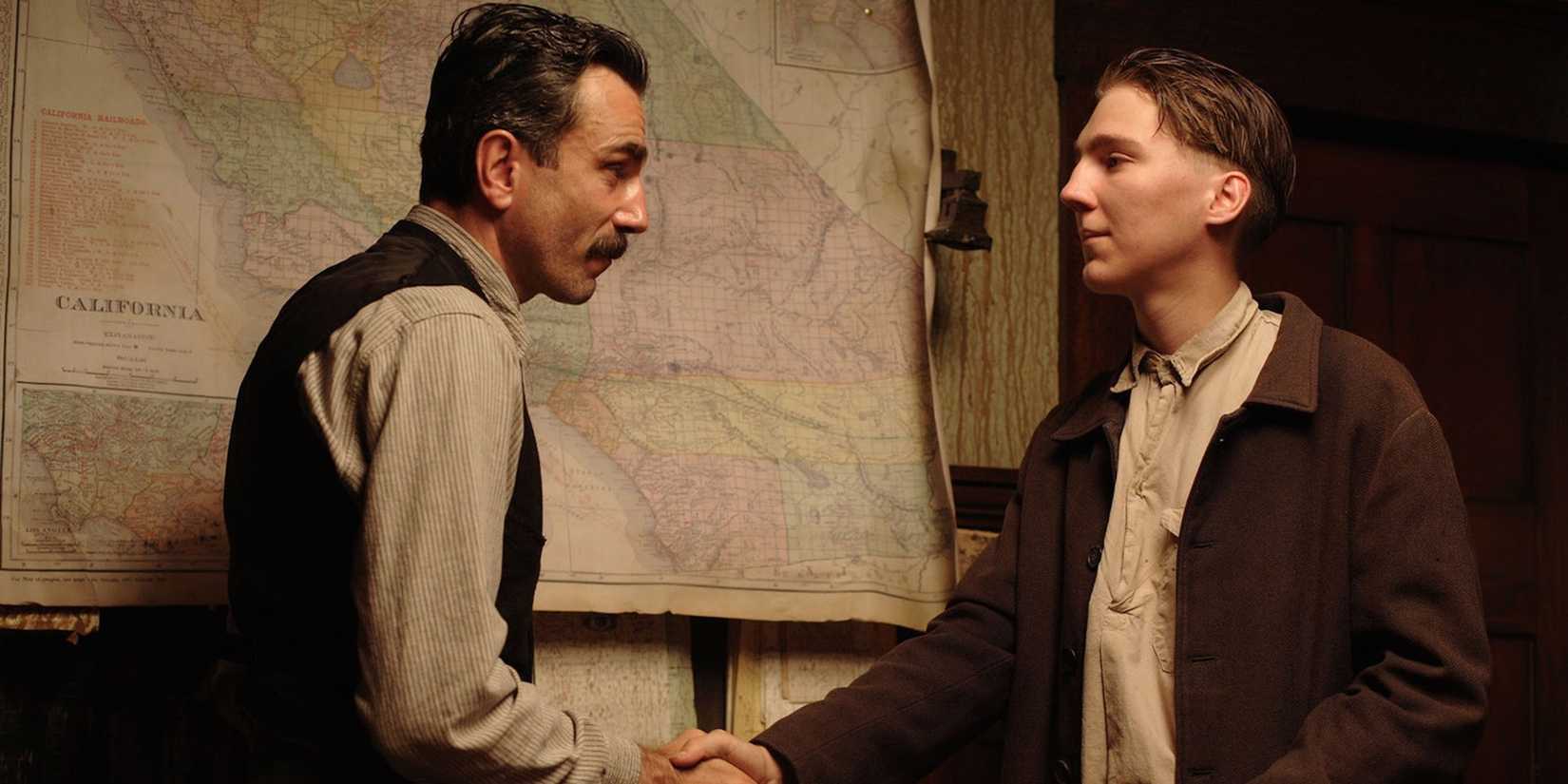 Eli Sunday (Paul Dano) and Daniel Plainview (Daniel Day Lewis) shaking hands in There Will Be Blood