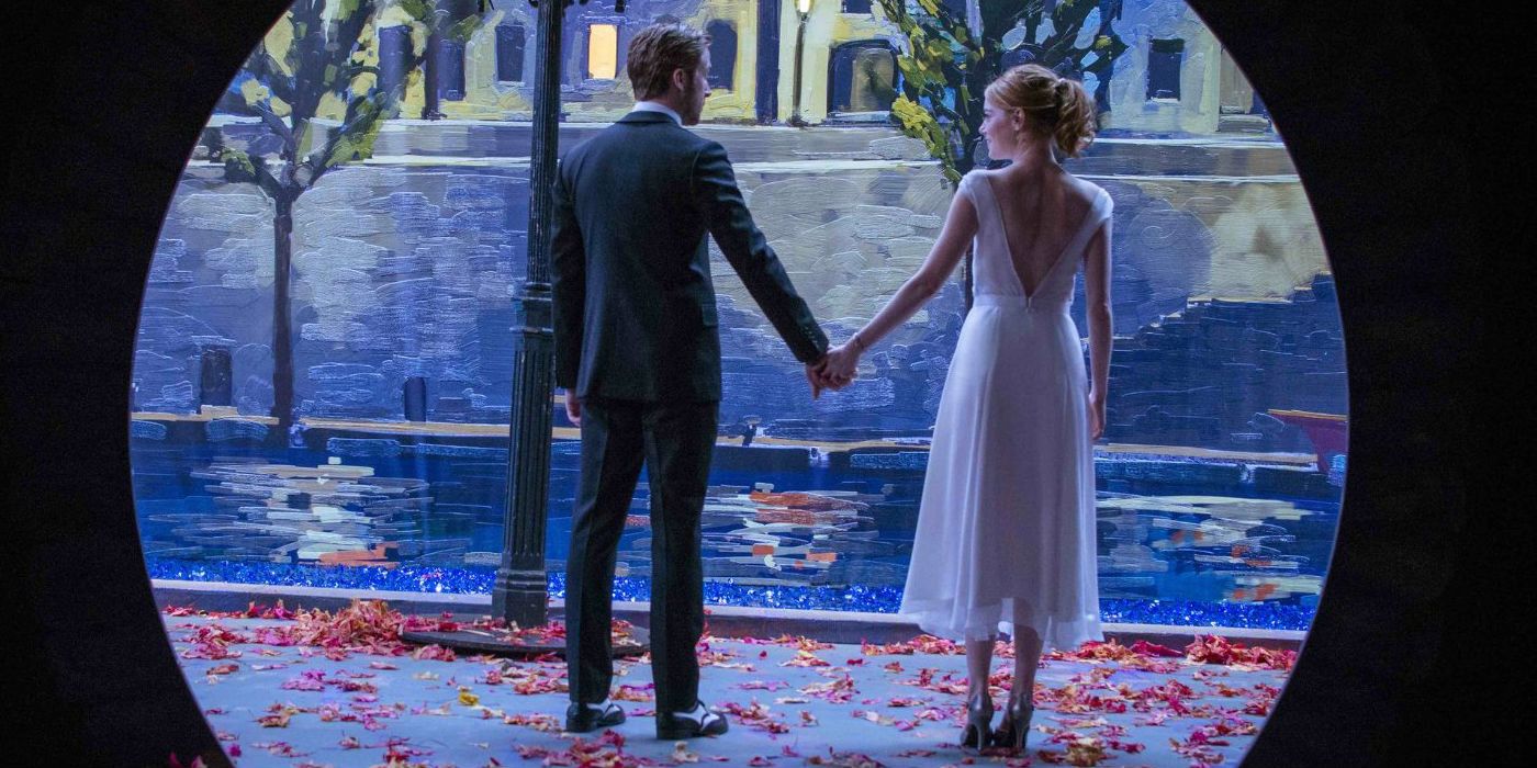 Ryan Gosling and Emma Stone holding hands as they stand by the water in La La Land