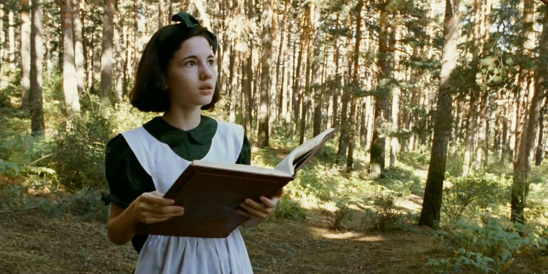 Ofelia in the woods with a book in Pan's Labyrinth