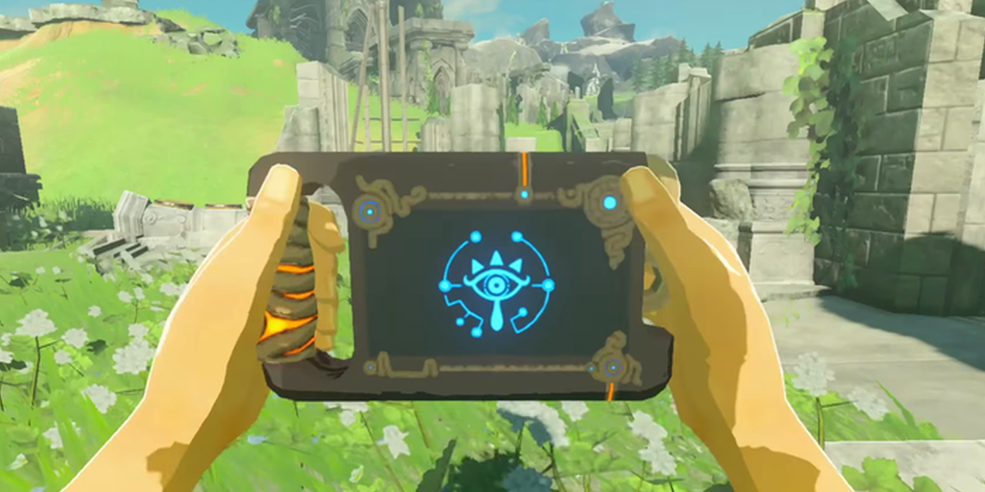 A first-person perspective of Link holding the Sheikah Slate in Breath of the Wild, with ruins in the background.