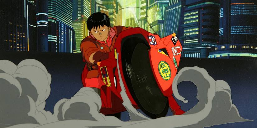 Akira animated movie screencap of Kaneda riding his iconic bike through the city streets.