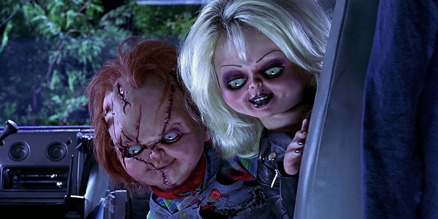 Chucky and Tiffany leaning around a seat in a van to look in the back in Bride of Chucky