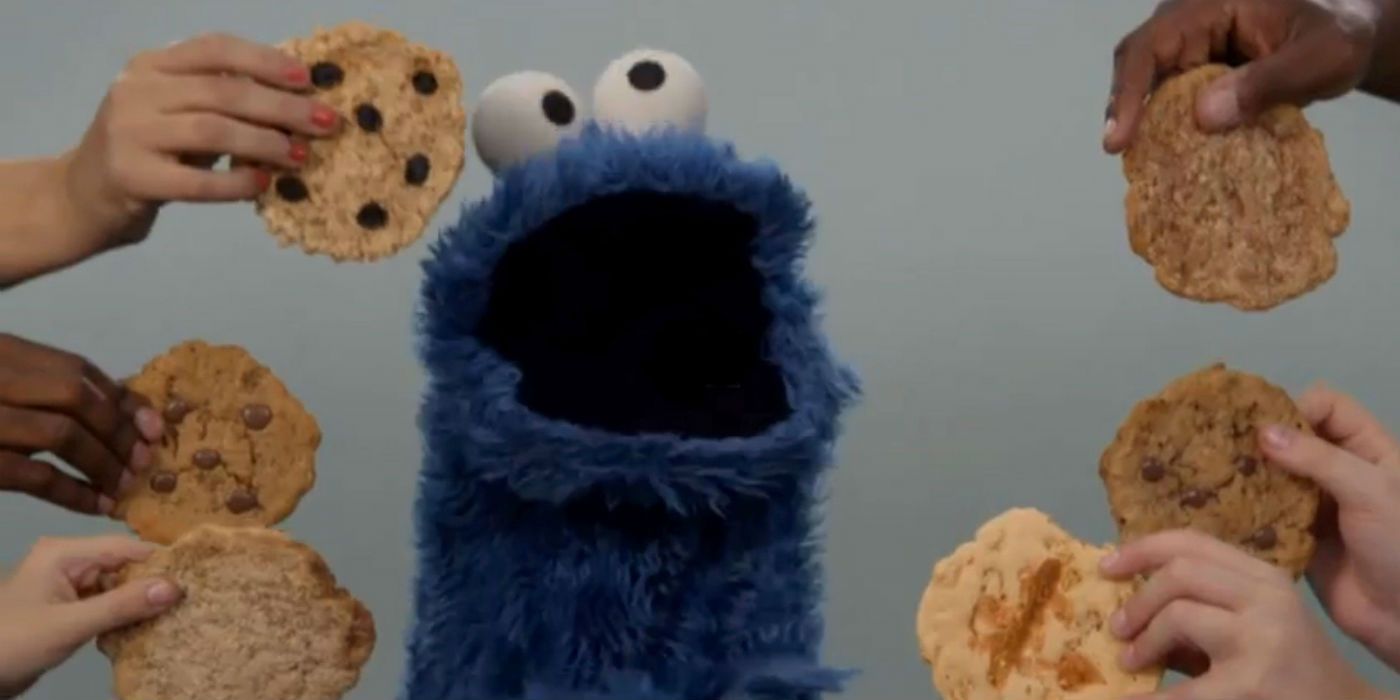 Hands Feeding Cookie Monster Cookies on Sesame Street